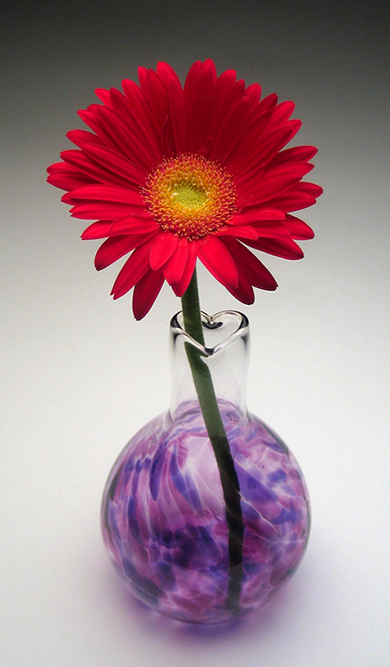 A Circle of Friends vase with a red gerbera daisy